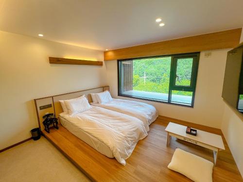 a bedroom with a bed and a large window at Hotel Ganwoljae in Ulsan