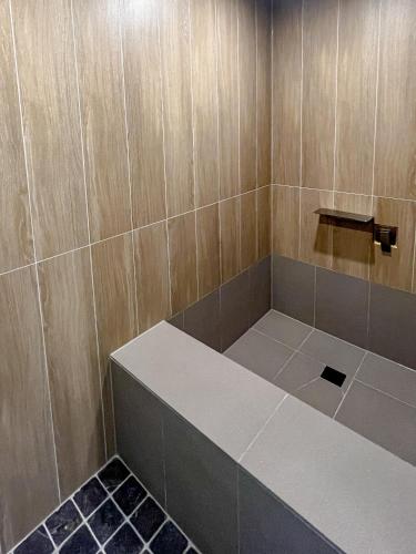 a shower with a bench in a tiled bathroom at Hotel Ganwoljae in Ulsan