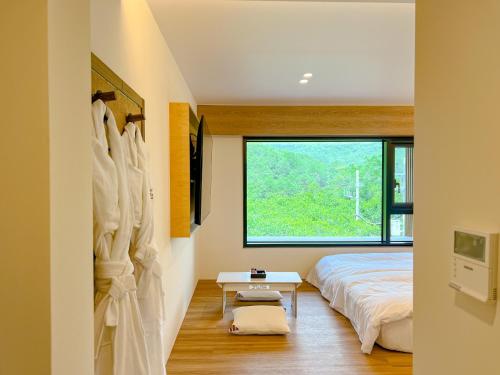 a bedroom with a bed and a window at Hotel Ganwoljae in Ulsan