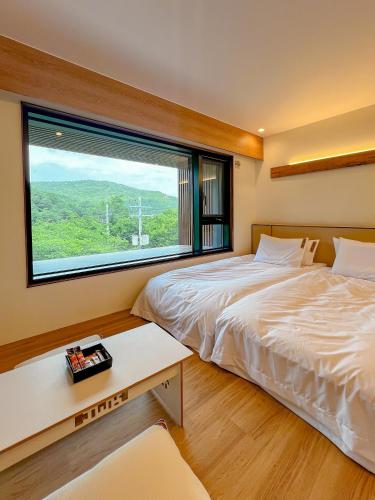 a bedroom with two beds and a large window at Hotel Ganwoljae in Ulsan