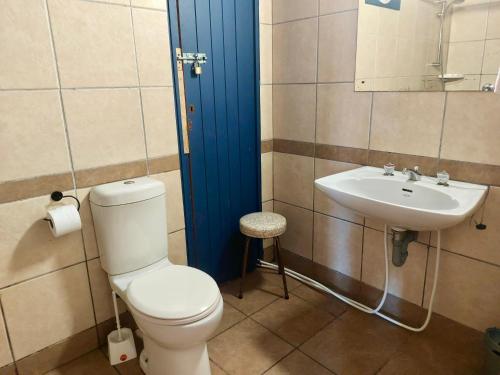 a bathroom with a toilet and a sink at Hoedjiesbaai Hotel in Saldanha