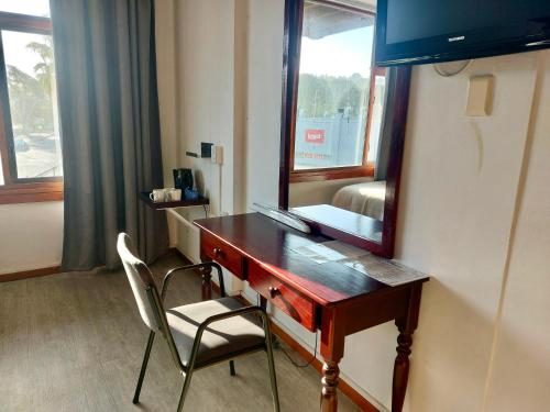 a desk with a mirror and a chair in a room at Hoedjiesbaai Hotel in Saldanha
