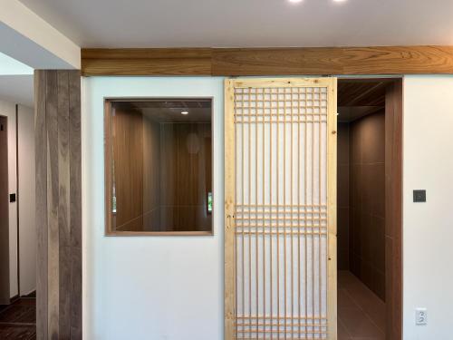 a pivot door in a room with a mirror at Hotel Ganwoljae in Ulsan