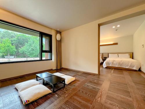a bedroom with two beds and a large window at Hotel Ganwoljae in Ulsan