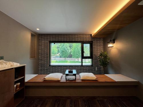 a window in a room with a bench in front of it at Hotel Ganwoljae in Ulsan