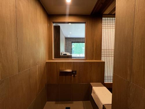 a bathroom with a window and a bench in it at Hotel Ganwoljae in Ulsan