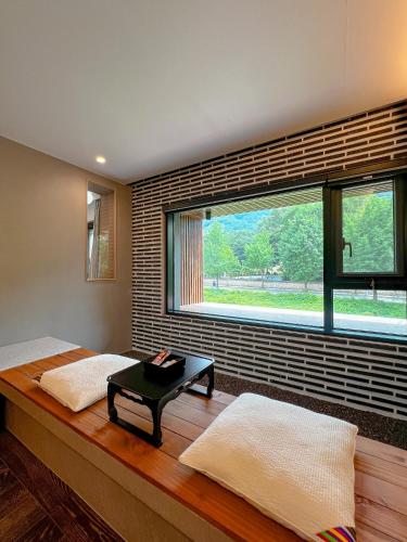 a bedroom with two beds and a large window at Hotel Ganwoljae in Ulsan