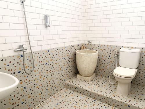 un bagno con un water e un lavandino di Tjahaja Baroe Syariah Mitra RedDoorz At Dukuh Kupang a Surabaya