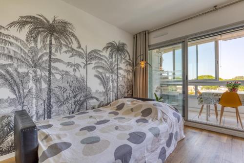 - une chambre avec un lit et une fresque murale sur les palmiers dans l'établissement Chez Nat n Rosy, à La Grande Motte