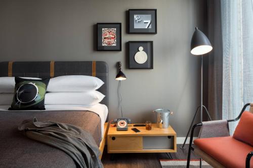 a bedroom with a bed and a table and a chair at Moxy San Diego Gaslamp Quarter in San Diego