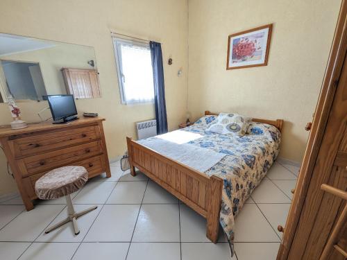 une chambre avec un lit, un bureau et une télévision dans l'établissement Villa T3 Spacieuse à Port-la-Nouvelle – Jardin, Parking, à 900m de la Plage, Chien Admis - FR-1-797-50, à Port-la-Nouvelle