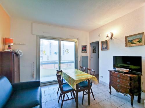 un salon avec une table et une télévision dans l'établissement Studio cabine 4 pers avec balcon, parking, tennis, proche plage - Le Lavandou - FR-1-803-27, au Lavandou