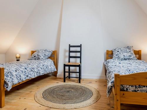 - une chambre avec 2 lits et un tapis sur du parquet dans l'établissement Chaumière au calme avec terrasse, à 9 km des plages, 3 chambres, parking privé et équipements bébé. - FR-1-306-1276, à Saint-Lyphard