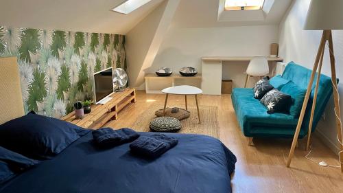 - un salon avec un lit bleu et un canapé dans l'établissement Appartement 3 chambres centre ville Cholet 25min du Puy duFou, à Cholet