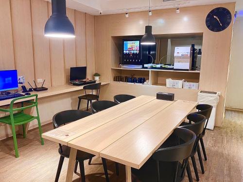 a conference room with a wooden table and chairs at Yomi Hotel - ShuangLian MRT in Taipei