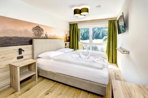 a bedroom with a large bed and a window at Das Förstereck in Viehhofen