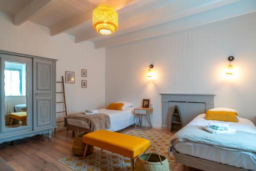 a bedroom with two beds and a chair and a fireplace at Ma Kalon - Maison pour 8 avec parking in Plomodiern