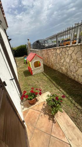 a dog house sitting next to a stone wall at CASA VACANZA FELICITA' in Porto Potenza Picena