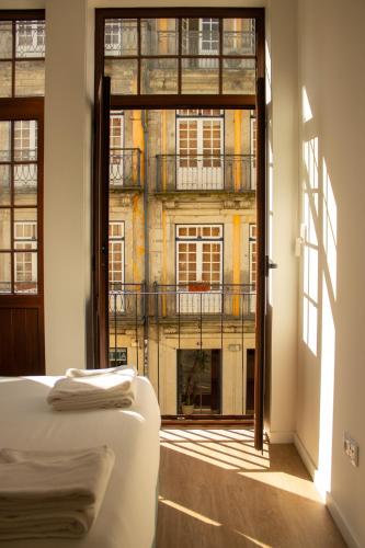 a bedroom with a view of a building from a window at ORM- Flores Apartment in Porto