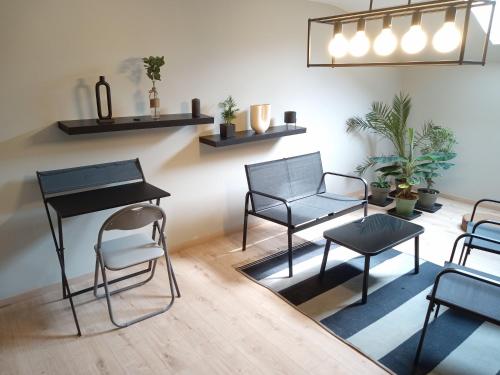 a room with chairs and a table and shelves at Le Vieux Noyer in Nassogne