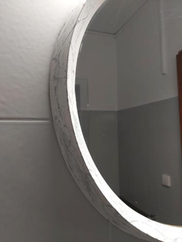 a mirror hanging on a wall in a bathroom at Potamolithos Suites 2 in Konitsa