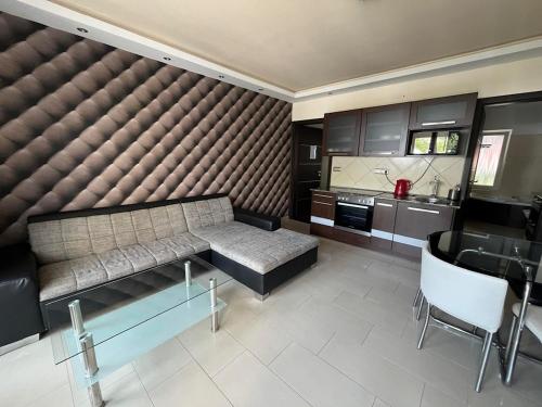 a living room with a couch and a kitchen at City Apartman ház in Balatonlelle