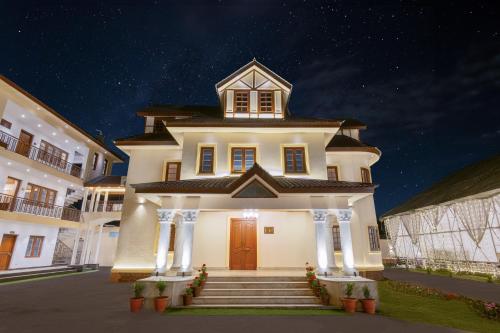a large white building with a clock tower on top at Moghal Mahal Resort Rajbagh Srinagar in Rājbāgh