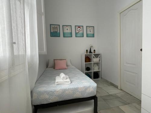 a small bedroom with a bed with two towels on it at La Casa de María Castaña in Seville