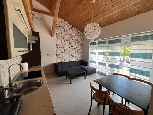 a kitchen and living room with a couch and a table at City Apartman ház in Balatonlelle