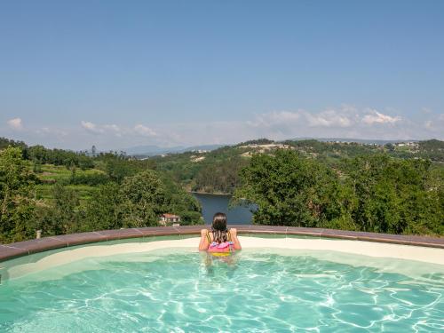 a woman sitting in a swimming pool at TAMACA nature in Marco de Canaveses