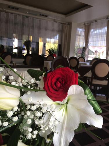 a red rose and white flowers on a table at Pensiunea Orizont in Poiana Brasov