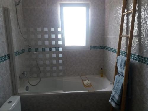 une salle de bain avec une baignoire et une fenêtre dans l'établissement Jolie villa avec un bel extérieur exposition Sud, à Pézenas