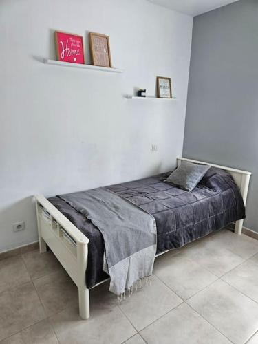 une chambre avec un lit dans une pièce blanche dans l'établissement Jolie villa avec un bel extérieur exposition Sud, à Pézenas