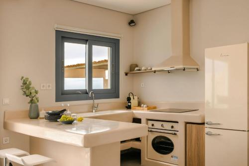 una cucina bianca con lavello e frigorifero di Villa Elena - Zen Villas a Fiskardho