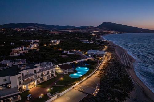 a view of the beach and the ocean at night at Bellevue Sardinia Resort Affiliated by Meliá in Valledoria