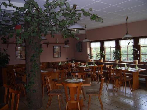 um restaurante com mesas e cadeiras e uma árvore em An der Linde em Eisenach