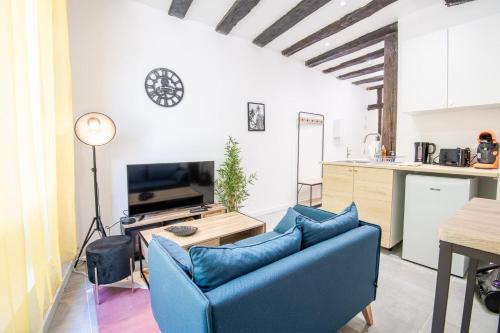 a living room with a blue couch and a kitchen at La Cachette d'Amboise - Appart. 2 pers. in Amboise
