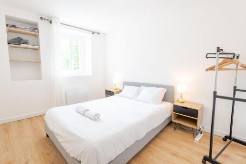 une chambre avec un lit blanc et une fenêtre dans l'établissement La Cachette d'Amboise - Appart. 2 pers., à Amboise