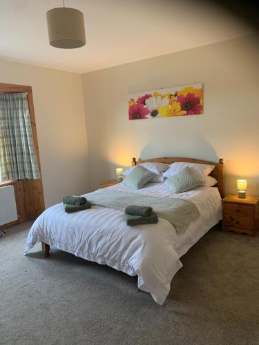 a bedroom with a large bed with two pillows at The Cottage at Hillhead Farm in St. Andrews
