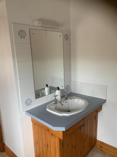 a bathroom with a sink and a mirror at The Cottage at Hillhead Farm in St. Andrews