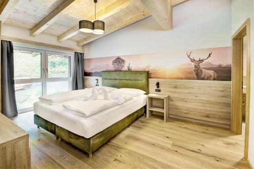 a bedroom with a bed with a deer painting on the wall at Das Förstereck in Viehhofen