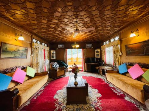 a living room with couches and a red rug at New Sea Palace Houseboats in Srinagar