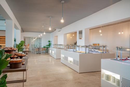 a bakery with a row of counters with pastries at Bellevue Sardinia Resort Affiliated by Meliá in Valledoria