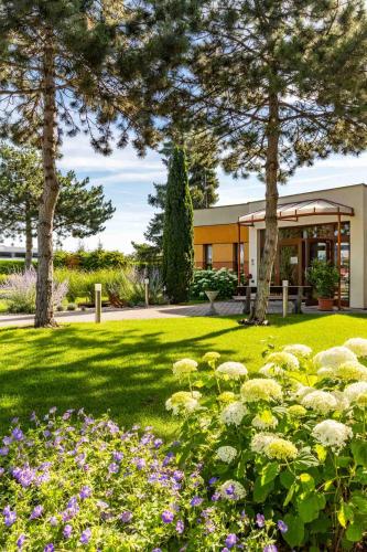 Un jardín con flores delante de un edificio. en Hotel garni Steinfeld, en Wiener Neustadt