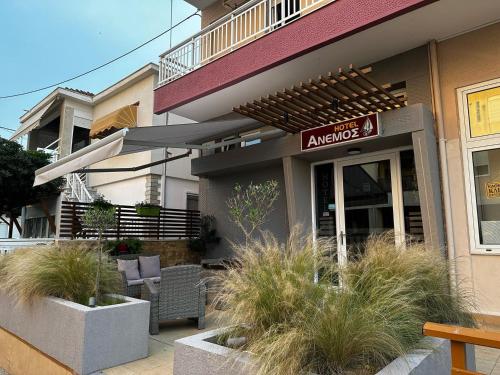 a building with a patio with chairs and an umbrella at Anemos in Agia Triada