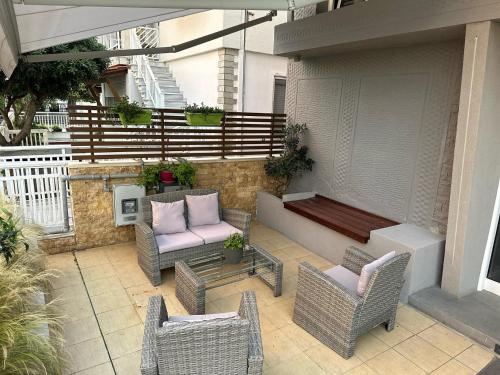 an outdoor patio with a bench and chairs at Anemos in Agia Triada