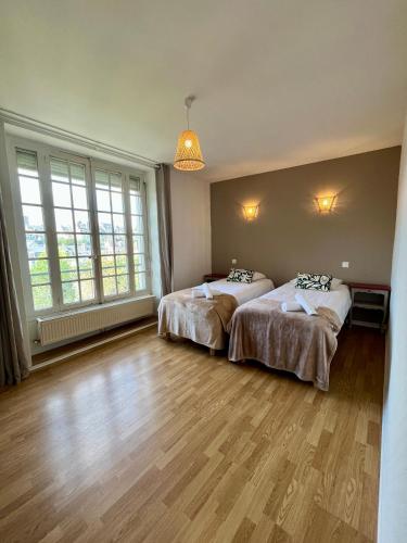 deux lits dans une chambre avec deux fenêtres dans l'établissement La Place du Château - Vue exceptionnelle sur le château de Blois, à Blois
