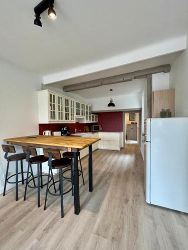 une cuisine avec une table en bois et un réfrigérateur dans l'établissement La Place du Château - Vue exceptionnelle sur le château de Blois, à Blois