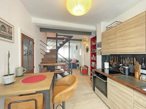 une cuisine avec une table et des chaises dans une pièce dans l'établissement Charming Triplex house heart of medieval town, à Moret-sur-Loing