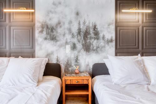 a bedroom with two beds and a painting of trees on the wall at Le Gentleman - Elégant - Confort - Calme in Douai